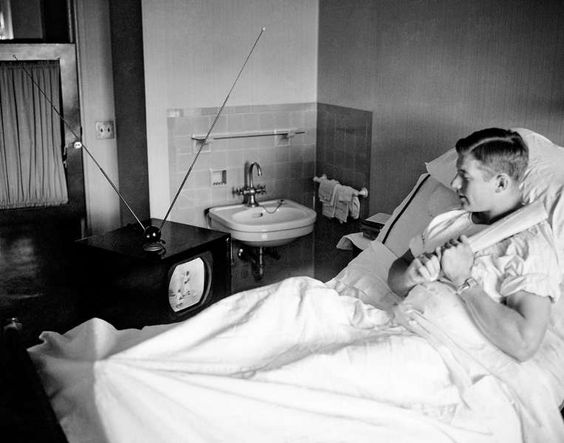 Lennox Hill Hospital, Manhattan, NY, October 6, 1951 – Rookie Mickey Mantle watches his Yankees play after hurting knee in World Series play