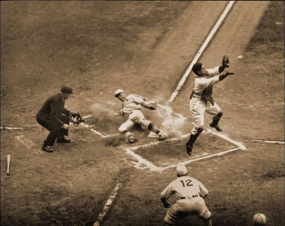 Navin Field, Detroit, MI, October 8, 1934 – Cards Jack Rothrock slides home safely under a leaping Mickey Cochrane of the Tigers in World Series action