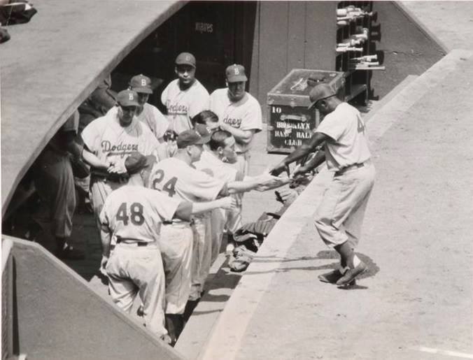 Polo Grounds, Manhattan, NY, May 29,1955 – Jackie Robinson is greeted by teammates after hitting home run